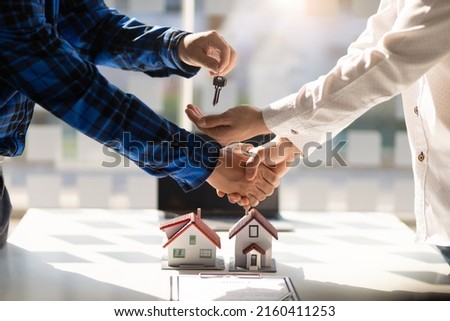 Real estate agent shake hand the signing of the agreement is complete, the keys to the house are given. Contractor engineer gives the customer the house key after the construction project is completed