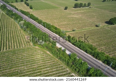 Transportation railway in Italy drone view. Railroad between vineyards diagonally aerial view. Royalty-Free Stock Photo #2160441269