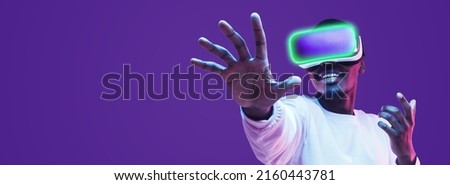 Banner of black man in vr headset exploring metaverse world, touching virtual reality subjects with copy space on the left Royalty-Free Stock Photo #2160443781