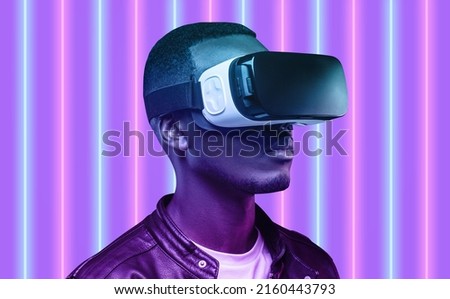 Head and shoulders picture of African American guy wearing 3d glasses with virtual projection for self-education issues, visiting famous museums using augmented reality gadget. Neon light