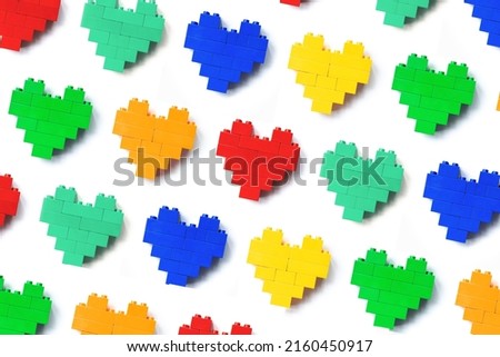 Colors Hearts from play blocks as background, minimal geometric pattern from plastic blocks, shapes heart from child construction. Top view repeat colorful pattern, Toys, games and recreation