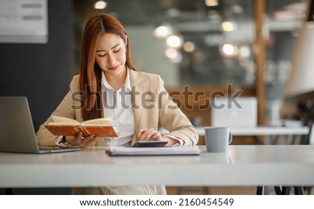 Asian businesswoman working happily about the success of the company,doing planning analyzing the financial report, business plan investment, finance analysis concept.