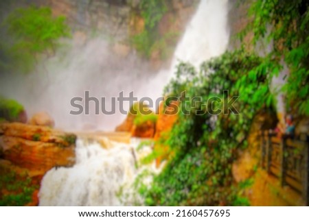 Defocused abstract background of Very beautiful waterfall. With green forest all around.
