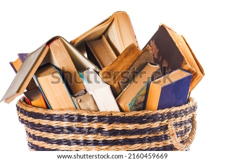 Various old books in a wicker basket. Isolated on white background.