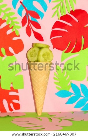 ice cream cone with cucumber slice, creative summer health design, healthy refreshing dessert, tropical colorful leaves on a pink-green background