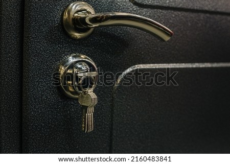 Close up photo with selective focus of door handle and lock with keys in it