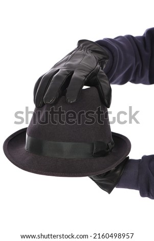 Man wearing black leather glove on white background, closeup. Felt hat in handSide view. High resolution photo. Full depth of field.