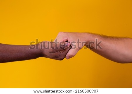 Caucasian woman and African American man holding hands together in backlight. racism concept
