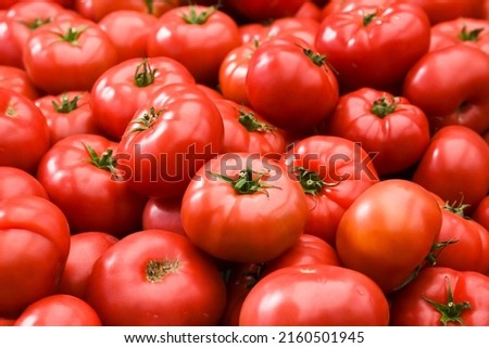Tomatoes stacked on top of each other in a supermarket for sale, tomato texture.
