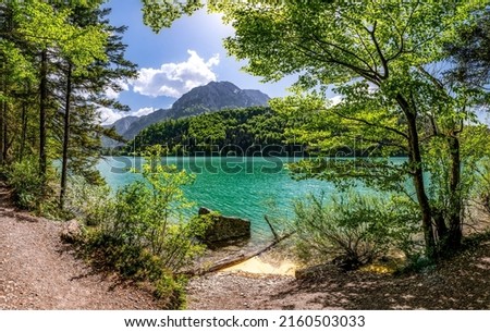On the shore of a mountain lake. Lakeshore in mountains. Beautiful lake in mountains. Mountain lake view Royalty-Free Stock Photo #2160503033