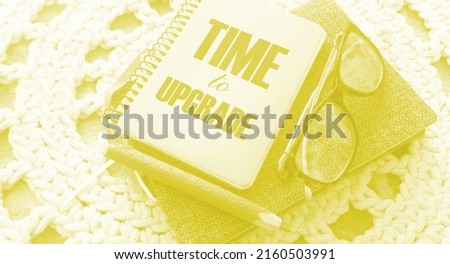Time to upgrade text on the cover of notebook, glasses and pen on crochet cloth. Business renew concept.