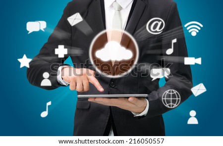 Businessman hand holding tablet cloud connectivity on blue background