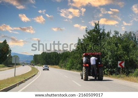 A tractor driving on the mountainous roads of the Black Sea transports people unsuitable for traffic.