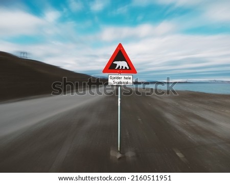 Polar Bear warning sign by the road leading out of Longyearbyen in Svalbard, Norway. Motion blur background.