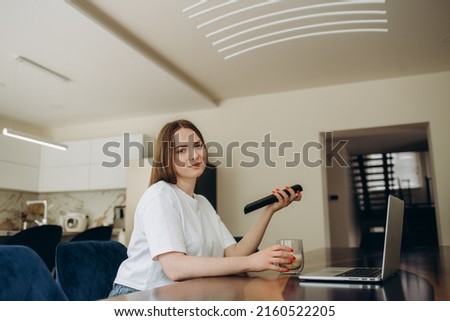 Happy homeowner resting on couch, watching movie on TV. Sport football fan relaxing at home, holding remote control, turning on football soccer game on sport channel. Digital television concept