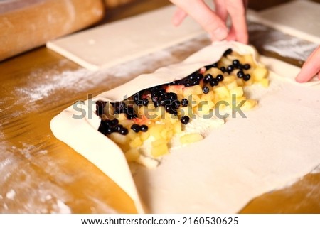 The process of making strudel from blueberries and apples.