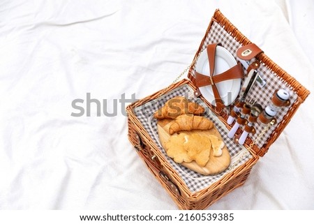 a picnic basket on the white blanket of the backyard