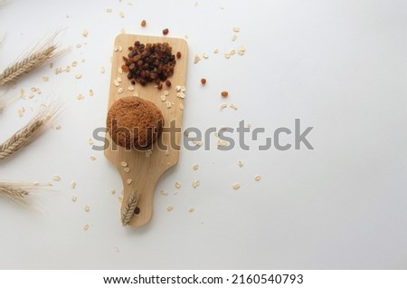 biscuits on a wooden board with oatmeal flakes on a white background, banner, view from above