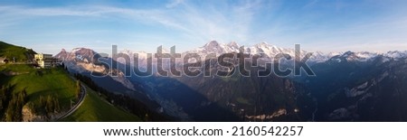 Panorama of Traditional Mountain Hotel and Swiss Mountains Eiger, Monch and Jungfrau from Schynige Platte, Lauterbrunnen Valley And Grindelwald Valley, Interlaken, Switzerland Royalty-Free Stock Photo #2160542257