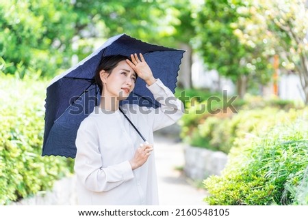 Asian woman with a parasol Royalty-Free Stock Photo #2160548105