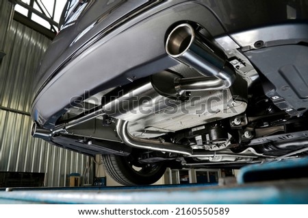 Sportive mufflers. Oval or round Car Exhaust Tailpipe chromed made of stainless steel on powerful sport car bumper. Exhaust silencer, metal fittings and pipes for the muffler Royalty-Free Stock Photo #2160550589