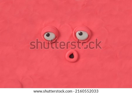 Ugly monster with an indifferent expression, fabulous creature made by hand from pink plasticine. Scary face of alien monster. 3d artwork