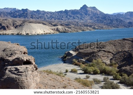 View of desert wash reaching the edge of Lake Mohave, part of the Colorado River reservoir system and Lake Mead National Recreation Area.  Royalty-Free Stock Photo #2160553821