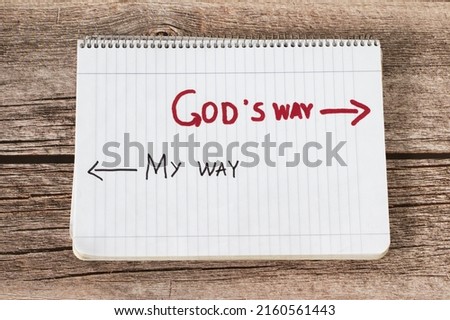 God's way, a handwritten text quote and arrows in a white notebook page placed on a wooden background. Follow the way of life with obedience to God Jesus Christ, biblical concept. Top view.	 Royalty-Free Stock Photo #2160561443