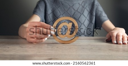 the woman holding wooden email sign on table background