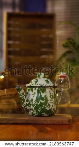 Teapot for making tea. In Indonesia, this teapot is called Teko Blirik. Made of zinc and enamel coating for heat resistance. Patterned like an army uniform. Indonesia.