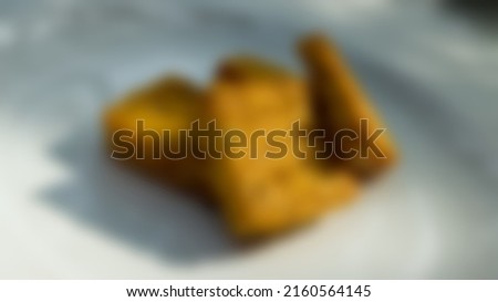 Blurred view of fried tempeh served on a white ceramic plate on a white background and a little shadow in the city of Bandung, West Java, Indonesia