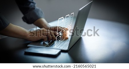 Business Hand using laptop computer with virtual screen and document for online approve paperless quality assurance and ERP management concept.