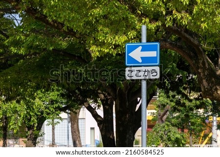 Road sign with arrow meaning one way, Japanese under the sign means "from here"