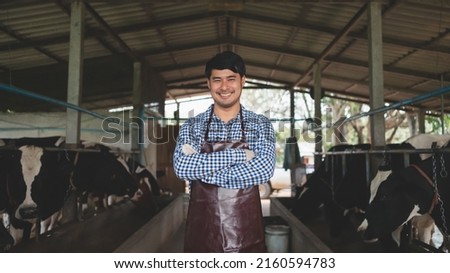 smiling and happy farmers at the dairy farm. Agriculture industry, farming and animal husbandry concept ,Cow on dairy farm eating hay. Royalty-Free Stock Photo #2160594783