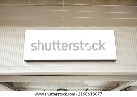 Mock up. White empty rectangular advertising sign board above entrance to store inside in shopping mall