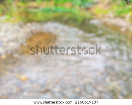 river with clear water Stones and grass on the river bank,  defocused abstract background of river