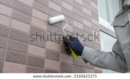 A man repairing the outer wall. Royalty-Free Stock Photo #2160621275