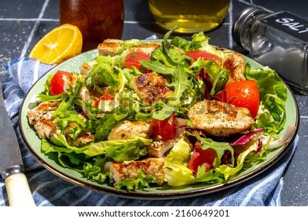 Healthy balanced diet food. Green salad with grill chicken breast fillet, tomatoes, olive oil top view copy space