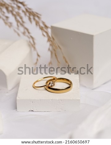 Wedding ring set on white stone. The jewelry ring is ready to be showcased and sold. The wedding ring is a sign of the love of the couple. Pearls and diamonds complete the ring's beauty. focus blur.