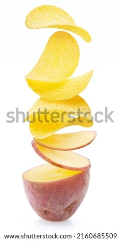 Raw potato cut on slices which are turning into delicious potato chips. Conceptual picture.