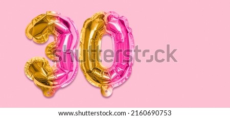 Rainbow foil balloon number, digit thirty on a pink background. Birthday greeting card with inscription 30. Anniversary concept. Top view. Numerical digit. Celebration event, template. Banner.