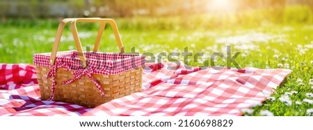 Picnic duvet with empty bascket on the meadow in nature. Panoramic view. Concept of leisure and family weekend. Royalty-Free Stock Photo #2160698829