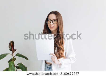 Happy woman business worker holding documents standing at office