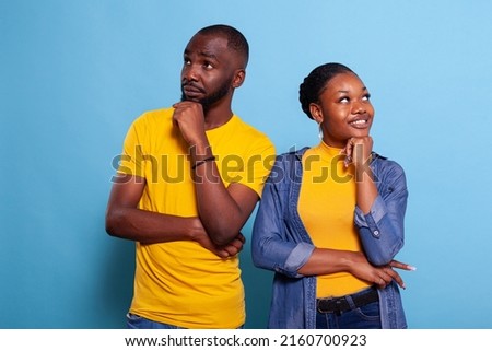 Thoughtful partners brainstorming ideas and looking sideways, feeling creative. Positive man and woman pondering solution and thinking about clever decision. Curious people in relationship. Royalty-Free Stock Photo #2160700923