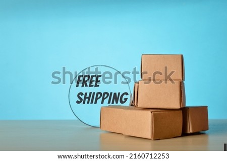 Cardboard boxes and magnifying glass with text FREE SHIPPING