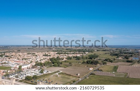 The aerial panoramic view of the medieval city of Aigues-Mortes and the Etang de la Ville, in petite Camargue, in the Gard department in the Occitanie region of southern France