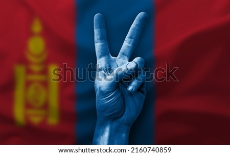 Hand making the V victory sign with flag of mongolia