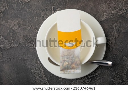 Buckwheat Tea Superfood. Close-up tea bag in a white tea cup on a black textured background. copy space.Place for text.