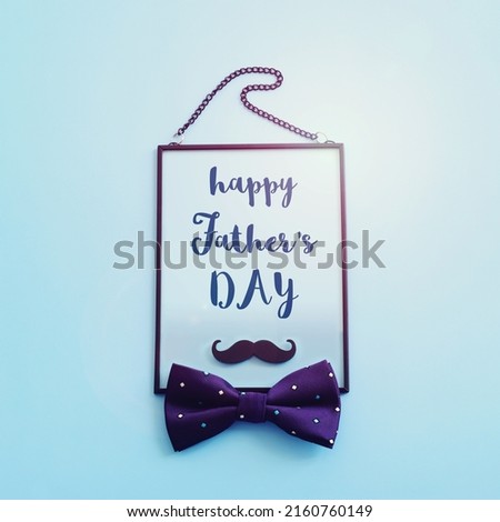 Father's day concept. bow tie, funny moustache and frame over blue background. top view, flat lay