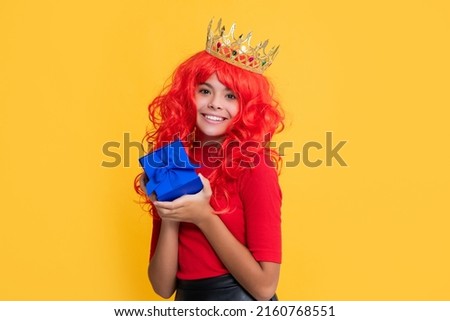 child smile in crown with present on yellow background